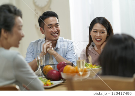asian family chatting while eating meal asian family chatting while eating meal 120417490