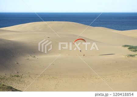 夏の鳥取県　鯨島を背景に鳥取砂丘で飛ぶパラグライダー 120418854