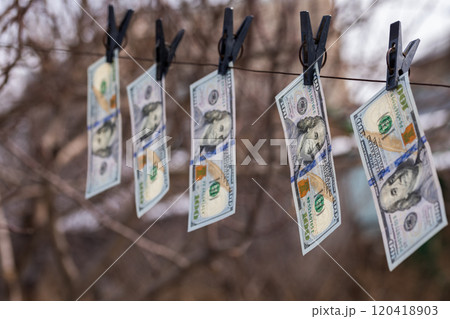 hundred-dollar bills hanging on a clothesline, secured with clothespins, symbolizing money laundering or financial dealings hundred-dollar bills hanging on a clothesline, secured with clothespins, symbolizing money laundering or financial dealings 120418903