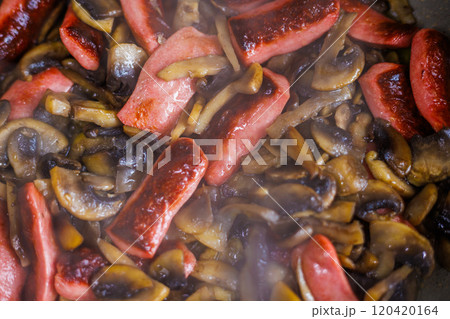 closeup view of roasting champignon mushrooms and sausages 120420164