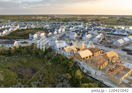 Wooden houses under construction in new developing suburban area. Development of residential housing in American suburbs. Real estate market in the USA Wooden houses under construction in new developing suburban area. Development of residential housing in American suburbs. Real estate market in the USA 120421042