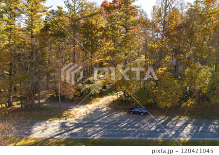 Winding parkway road in colorful mountain forest with yellow canopies in autumn at sunset. Driving in North Carolina wild woods nature in fall season Winding parkway road in colorful mountain forest with yellow canopies in autumn at sunset. Driving in North Carolina wild woods nature in fall season 120421045