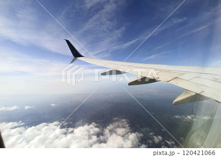 View through airplane window of commercial jet plane wing flying high in the sky. Air travelling concept View through airplane window of commercial jet plane wing flying high in the sky. Air travelling concept 120421066