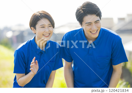 青いポロシャツを着た男女 120421834