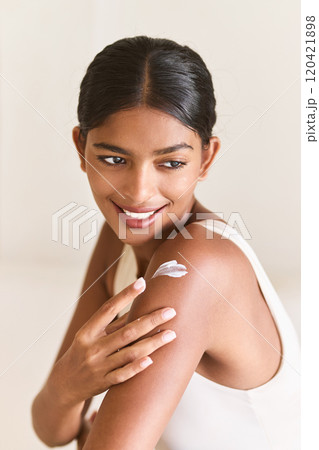 Radiant Woman Applying Skincare Cream Joyfully on Her Shoulder Radiant Woman Applying Skincare Cream Joyfully on Her Shoulder 120421898