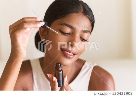 Woman Applying Facial Serum for Natural Glowing Skin in Bright Room Woman Applying Facial Serum for Natural Glowing Skin in Bright Room 120421902