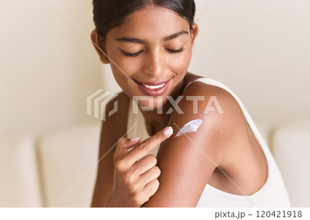 Smiling Woman Applying Moisturizer for Healthy Glowing Skin Smiling Woman Applying Moisturizer for Healthy Glowing Skin 120421918