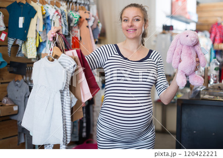 Happy pregnant woman posing in clothing store Happy pregnant woman posing in clothing store 120422221