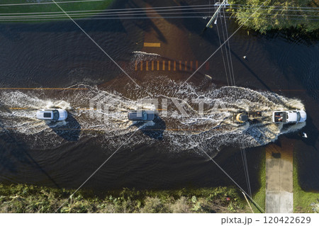 Hurricane flooded street with moving cars and surrounded with water houses in Florida residential area. Consequences of natural disaster 120422629
