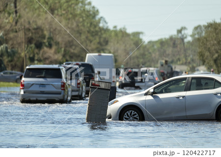 Flooded road in Florida after heavy hurricane rainfall. Evacuating cars and surrounded with water houses in suburban residential area 120422717
