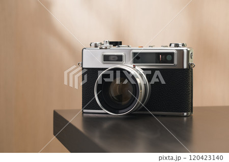 A vintage film camera sits elegantly on a table, showcasing timeless craftsmanship. 120423140