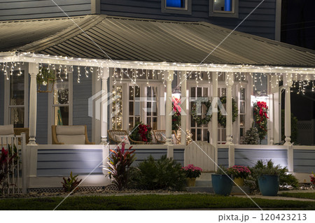 Brightly illuminated Christmas decorations on front yard porch of Florida family home. Outside decor for winter holidays Brightly illuminated Christmas decorations on front yard porch of Florida family home. Outside decor for winter holidays 120423213