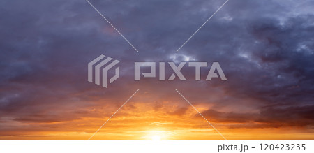 Bright colorful orange and yellow clouds on horizon. Beautiful sunset sky scenery 120423235