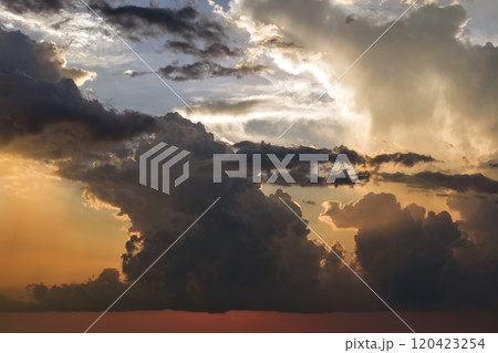 Beautiful sunset sky scenery. Bright colorful orange and yellow clouds on horizon 120423254