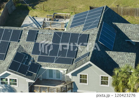 American residential house with rooftop covered with solar photovoltaic panels for producing of clean ecological electrical energy in suburban rural area. Concept of autonomous home American residential house with rooftop covered with solar photovoltaic panels for producing of clean ecological electrical energy in suburban rural area. Concept of autonomous home 120423276