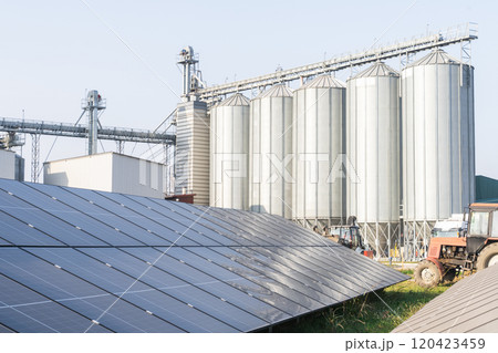 Modern farm using renewable energy. Solar panels with silos in the background. Modern farm using renewable energy. Solar panels with silos in the background. 120423459