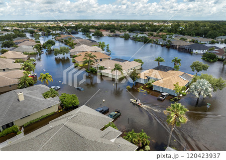Aftermath of hurricane Debby flooding natural disaster. Boat floating on flooded street surrounded by tropical storm rainfall flood waters homes in Sarasota, Florida residential area 120423937
