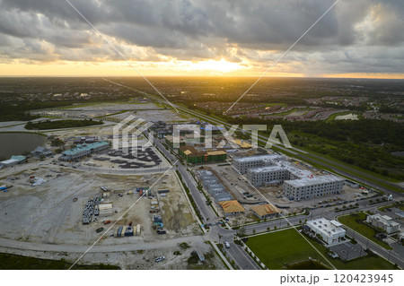 Aerial view of unfinished frames of apartment buildings ready for mounting wooden roof beams under construction. Development of residential housing in american suburbs. Real estate market in the USA 120423945