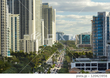 Aerial view of Sunny Isles Beach city with congested street traffic and luxurious highrise hotels and condos on Atlantic ocean shore. American tourism infrastructure in southern Florida 120423956