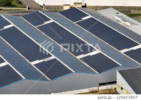 Aerial view of solar power plant with blue photovoltaic panels mounted on industrial building roof for producing green ecological electricity. Production of sustainable energy concept 120423957