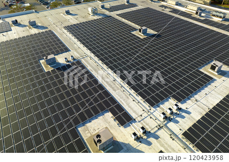 Aerial view of solar power plant with blue photovoltaic panels mounted on industrial building roof for producing green ecological electricity. Production of sustainable energy concept Aerial view of solar power plant with blue photovoltaic panels mounted on industrial building roof for producing green ecological electricity. Production of sustainable energy concept 120423958