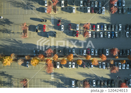 Aerial view of many colorful cars parked on parking lot with lines and markings for parking places and directions. Place for vehicles in front of a strip mall plaza Aerial view of many colorful cars parked on parking lot with lines and markings for parking places and directions. Place for vehicles in front of a strip mall plaza 120424013