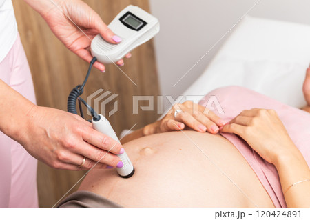 Using a fetal Doppler to monitor the heartbeat of a baby during prenatal care 120424891