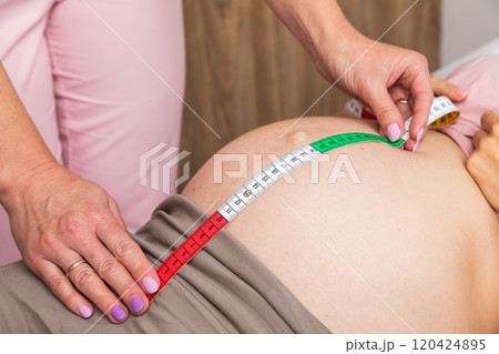 Doctor measuring a pregnant belly with a tape 120424895