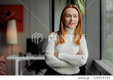 Content woman looks out office window Content woman looks out office window 120425195