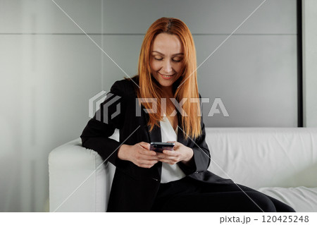 Woman Using Smartphone on Couch Woman Using Smartphone on Couch 120425248