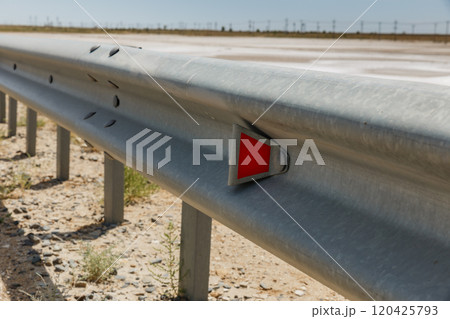 red road reflectors along the road. metal road fencing. Road and traffic safety 120425793