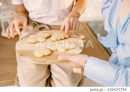Cropped photo of a wooden tray with a homemade cookies. Family preparation holiday food. Mother and daughter cooking cookies. Cropped photo of a wooden tray with a homemade cookies. Family preparation holiday food. Mother and daughter cooking cookies. 120425794