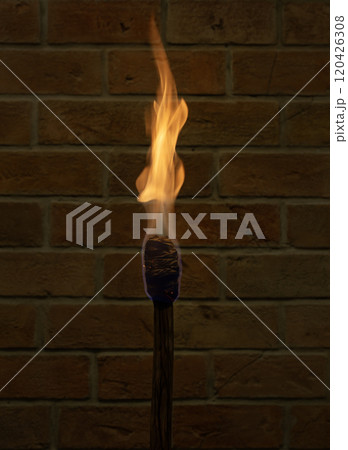 Burning wooden torch against brick wall. Burning wooden torch against brick wall. 120426308