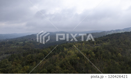 Layers of wooded hills fading into misty distance under cloudy sky 120426421