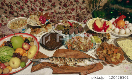A table for Media Noche or New Year eve feast with diverse traditional Filipino auspicious dishes and a grilled fish as centerpiece showing the authentic ritual culture and beliefs of the Philippines  120426501