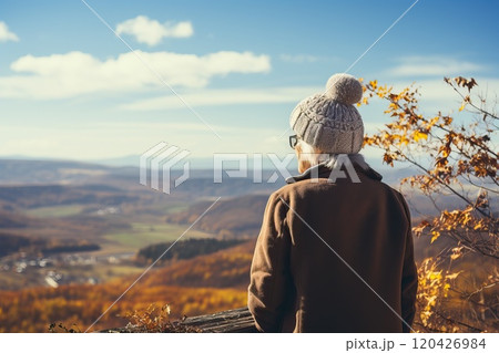 Portrait of an elderly woman looking at the mountain scenery in autumn. Portrait of an elderly woman looking at the mountain scenery in autumn. 120426984