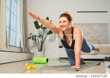 Yoga fitness workout training. Woman practicing yoga at home. Plus size female doing sports exercise on yoga mat indoor. Girl in sportswear have training workout for weight loss. Sport and fitness 120427120