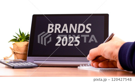 Planning brands 2025 new year symbol. Concept words Brands 2025 on beautiful black tablet. Beautiful white background. Businessman hand. Business brands 2025 new year concept. Copy space. Planning brands 2025 new year symbol. Concept words Brands 2025 on beautiful black tablet. Beautiful white background. Businessman hand. Business brands 2025 new year concept. Copy space. 120427548