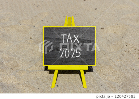 Planning tax 2025 new year symbol. Concept words Tax 2025 on beautiful yellow chalk blackboard. Beautiful sand beach background. Business tax 2025 new year concept. Copy space. 120427583