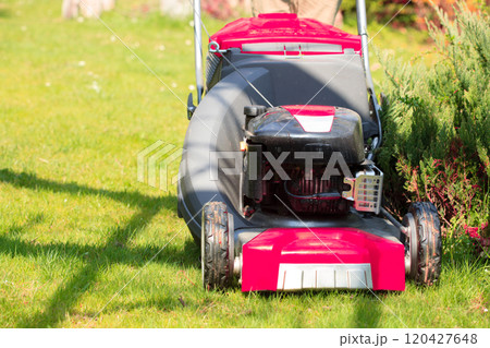Gardening. Mowing green lawn with red lawnmower Gardening. Mowing green lawn with red lawnmower 120427648