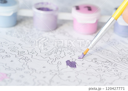 Close-up of paint by numbers canvas with purple brushstroke and paint pots Close-up of paint by numbers canvas with purple brushstroke and paint pots 120427771