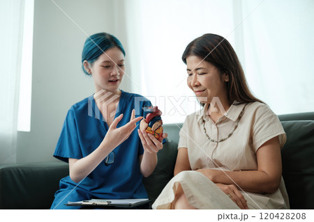 A woman is sitting on a couch with a doctor A woman is sitting on a couch with a doctor 120428208