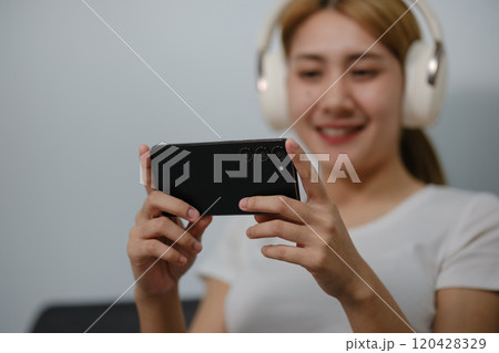 A woman is smiling while holding a cell phone 120428329