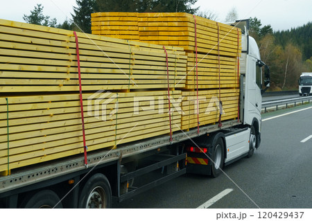 A truck transports lumber - boards on a motorway on a semi-trailer. A truck transports lumber - boards on a motorway on a semi-trailer. 120429437