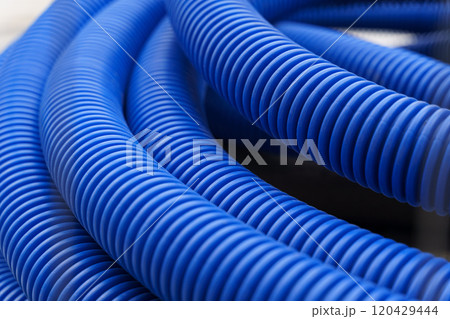 There is a blue corrugated pipe on the construction site. The texture of the pipe close-up 120429444
