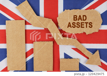 On the flag of Great Britain lie a chart, a down arrow and a sign that says - bad assets 120429475