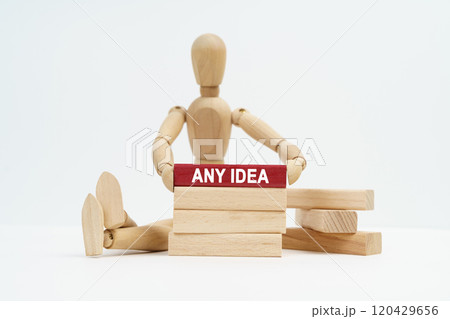 On a white surface sits a wooden man in his hands a block with the inscription - Any Idea 120429656