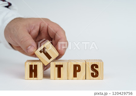 On a white surface, a man stacks cubes with the inscription - HTTPS 120429756