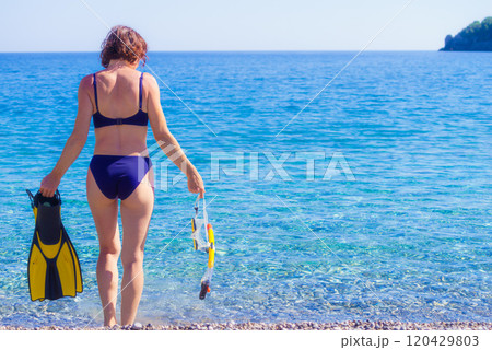 Woman with flippers snorkeling tube on beach Woman with flippers snorkeling tube on beach 120429803