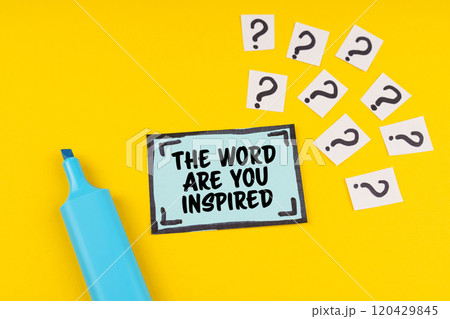 On the yellow surface is a marker, question marks and a sticker with the inscription - THE WORD ARE YOU INSPIRED On the yellow surface is a marker, question marks and a sticker with the inscription - THE WORD ARE YOU INSPIRED 120429845